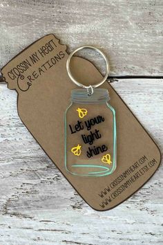 a keychain that says, let your light shine in a mason jar on a wooden background