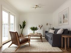 a living room filled with furniture and a wooden coffee table in front of a window