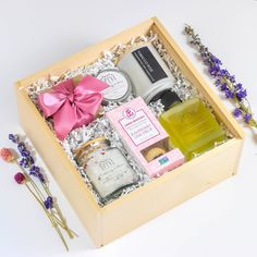 an open wooden box filled with different types of soaps and body care products next to lavender flowers