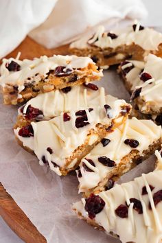 a wooden platter filled with white chocolate and cranberry bars