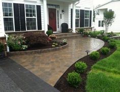 a brick walkway leading to a white house