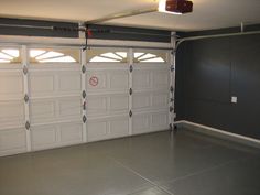 an empty garage with three doors and no one in the room or on the floor