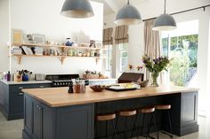 a kitchen with two hanging lights over the island