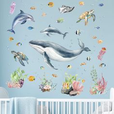 a baby's room with dolphins and sea animals on the wall, under water bubbles