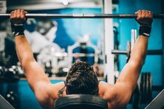 a man is doing squats on a barbell in a crossfit gym