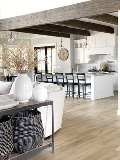 a living room filled with furniture and a large white vase on top of a table