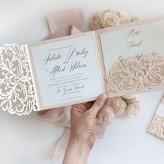 a person holding two wedding cards in their hands