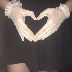 two hands in the shape of a heart made out of white gloves on top of a woman's chest