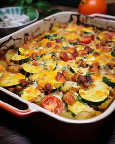 a casserole dish with zucchini, tomatoes and other vegetables in it