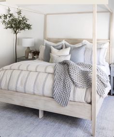 a bedroom with a four poster bed and white walls