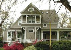 a large house with white trim on the front and side of it's windows