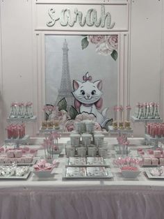 a table topped with lots of desserts next to a sign that says paris on it