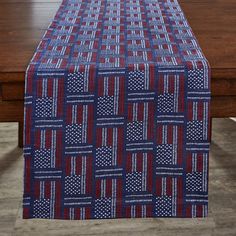 a blue and red table cloth with white polka dots on it, in front of a wooden table