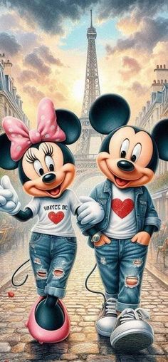 two mickey and minnie mouses standing in front of the eiffel tower