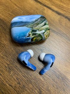 two ear buds sitting on top of a wooden table