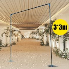 an empty room with 3m tall poles and flowers on the ground in front of it