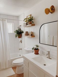 a bathroom with white walls and wooden floors