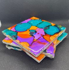 three colorful coasters are stacked on top of each other