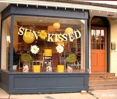 the sun kissed storefront is decorated with yellow and white decorations