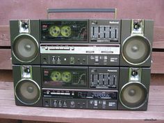 there are four stereos stacked on top of each other in front of a bench