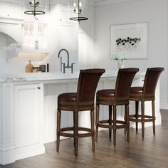 three brown leather bar stools sitting in front of a kitchen island