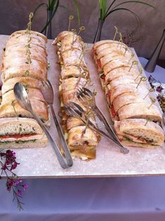 a table topped with sandwiches and silverware