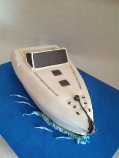 a cake shaped like a boat sitting on top of a blue mat