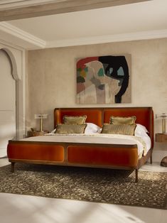 a large bed sitting in the middle of a bedroom next to a painting on the wall