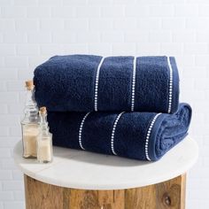 two blue towels sitting on top of a wooden table next to a bottle of liquid