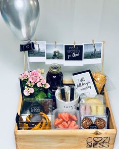 a wooden box filled with lots of food and condiments next to a balloon