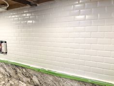 a kitchen with white and green tiles on the wall