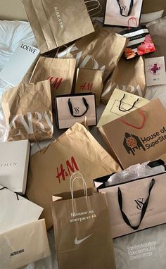 many shopping bags are piled on top of each other