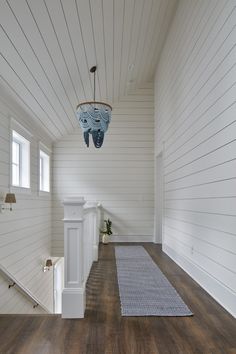 an empty room with white walls and wood flooring is seen in this image from the hallway