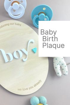 the baby birth plaque is surrounded by its accessories and toys, including pacifiers