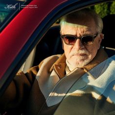 an older man wearing sunglasses sitting in a car