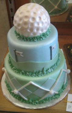 a three tiered cake with a golf ball on top