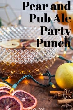 pear and pub ale party punch on a table with oranges, cinnamon sticks, lemon slices