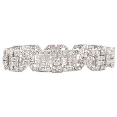 This exquisite diamond bracelet is expertly crafted in solid platinum, weighing 44.3 grams and measuring 6 3/4” around the wrist x 15mm wide. Displaying of a stunning geometric open-work Art Deco pattern studded in an array of diamonds. Composed of three prominent bezel-set, round diamonds weighing approximately, 1.25 carats. Further accented by 168 prong-set European round diamonds, collectively weighing approximately, 15.96 carats. Channel set with 12 baguette diamonds weighing approximately, High Jewelry Bracelet, Platinum Bracelet, Filigree Bracelet, Antique Filigree, Retro Bracelet, Bracelet Tennis, Deco Pattern, Art Deco Bracelet, Work Art