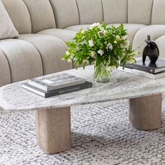 a marble coffee table with flowers and books on it