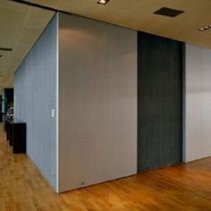 an empty room with several partitions in the middle and hard wood flooring on the other side