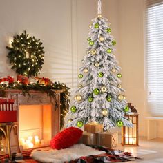 a white christmas tree with green and gold ornaments in a living room decorated for the holidays