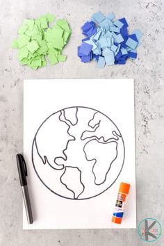 the earth is surrounded by colored crayons and markers on a sheet of paper