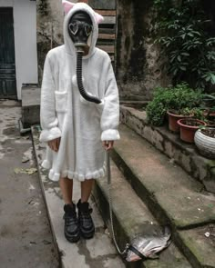 a person in a cat costume with a gas mask on and a leash attached to their mouth