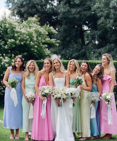 a group of women standing next to each other on top of a lush green field