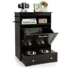 an open black cabinet with two bowls in it