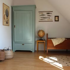 a room with a bed, blue door and wooden furniture in the corner is shown