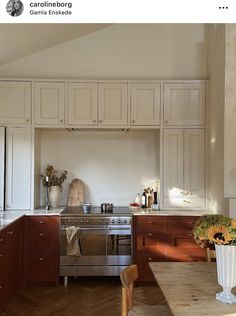 a kitchen with wooden floors and white walls, has an oven in the middle that is built into the wall