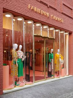 mannequins in glass cases on the outside of a clothing store