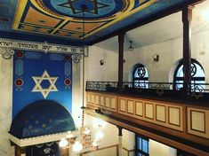 an ornately decorated room with blue and gold paint on the ceiling, two large circular windows