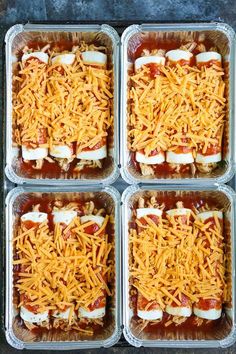 four plastic containers filled with food covered in cheese and toppings on top of each other